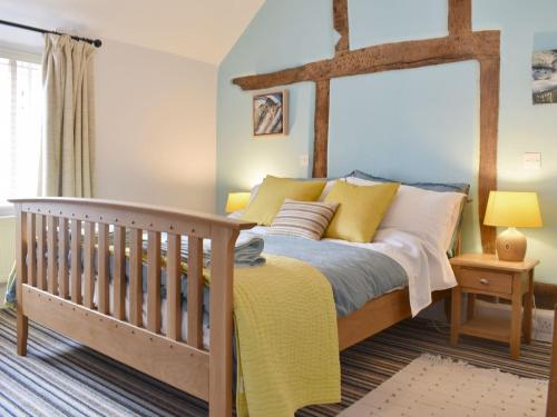 温什科姆Cenwulf Cottage的一间卧室配有一张床和一张婴儿床