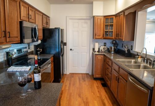 仙纳度A Time To Chill的厨房配有木制橱柜和黑色冰箱。
