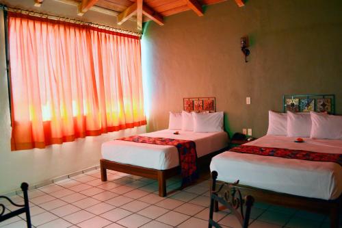 科利马阿尔达马酒店的酒店客房设有两张床和窗户。