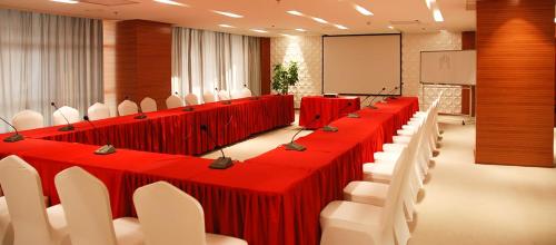 乌兰巴托乌兰巴托高级酒店的一间会议室,配有红色的桌子和白色的椅子