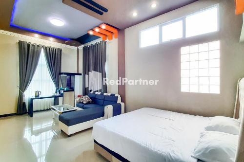 PondokpematangtanahMT Syariah Homestay Kerinci RedPartner的一间卧室配有一张床和一张蓝色的沙发