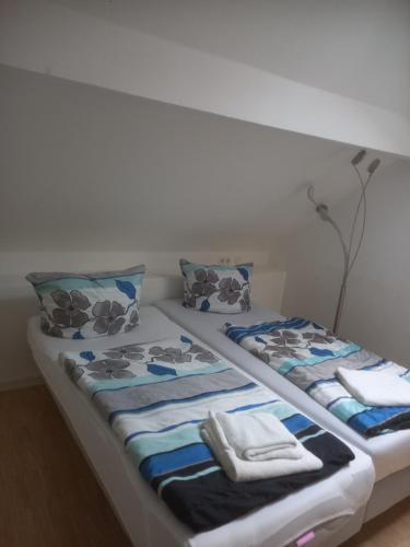 斯图加特Hotel Wiesbadener Hof的一张带蓝色和白色床单及枕头的床