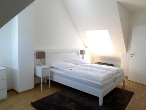 恩丁根Braviscasa - Ferienresidenz Badnerstrasse Endingen的白色的卧室设有白色的床和窗户。