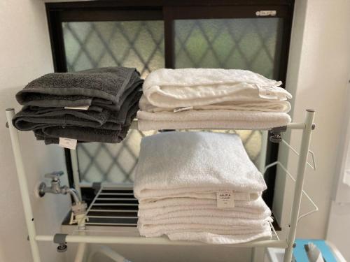 秩父 思源屋的浴室内架上的毛巾堆