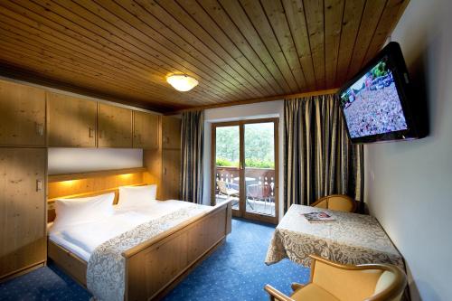 基茨比厄尔附近奥拉赫Hotel Wiesenegg的配有一张床和一台平面电视的酒店客房