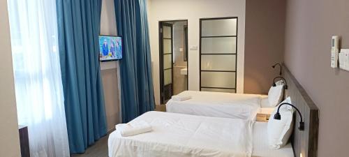 SimanggangRoxy Hotel Sri Aman的一间医院间,配有两张床和镜子
