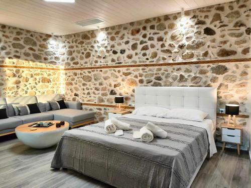 卡兰巴卡Dream Nest Meteora的一间卧室设有一张大床和石墙
