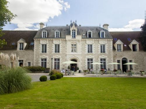 费尔昂塔德努瓦弗尔城堡酒店的一座带绿色草坪的大型石屋