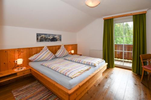 斯拉德明Strickhof的一间卧室配有一张带绿色窗帘的木床