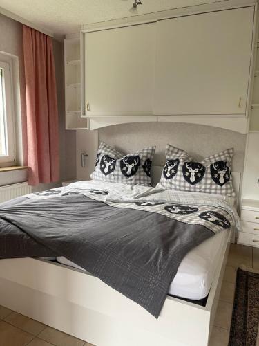博登斯多夫Seeappartement LUNA am Ossiachersee的一间卧室配有一张带黑白枕头的床