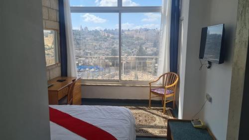 耶路撒冷耶路撒冷全景酒店 的卧室设有窗户,享有城市美景