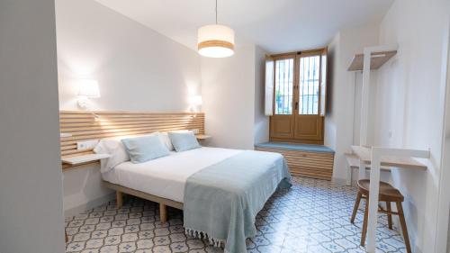 EsteponaVeranera Hostel的一间卧室配有一张床、一张书桌和一个窗户。