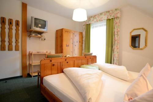 魏森湖玫瑰湖福鲁克斯住宿加早餐旅馆的一间卧室设有两张床、一台电视和一扇窗户。