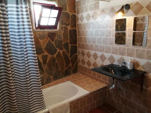 雷根古什-迪蒙萨拉什Casa Monreal的浴室配有盥洗盆、浴缸和盥洗盆