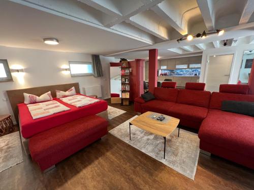 腓特烈港Haus Pia Executive Suites的客厅配有红色的沙发和桌子
