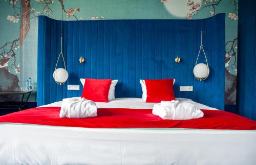 比尔什托纳斯Ego SPA的一张配有红色和白色枕头的大床
