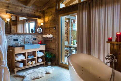 茨维泽尔Bayerischer Wald Chalets的一间带浴缸的浴室,位于一个木墙客房内
