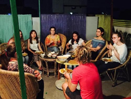 斋浦尔Chalo Eco Hostel的一群人坐在桌子旁