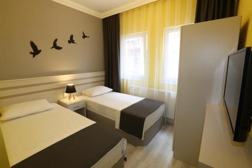 埃迪尔内Kaleroom EDİRNE的酒店客房设有两张床和电视。