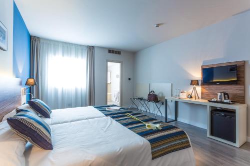 格拉纳达格拉纳达城市之梦酒店的卧室配有一张大床,墙上配有电视