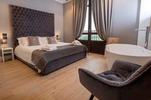 MontemagnoMontalbera Wine Suites的一间卧室设有一张大床和一个浴缸