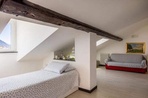 卡莫利La mansarda sul Porto的阁楼上设有一间卧室,配有两张床和一张沙发