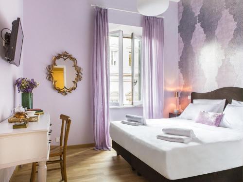 罗马萨洛托蒙蒂酒店的一间卧室配有一张床、一张书桌和一面镜子