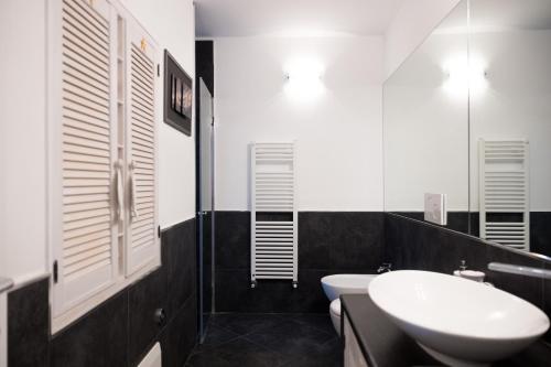 卡莫利La mansarda sul Porto的黑白浴室设有水槽和卫生间