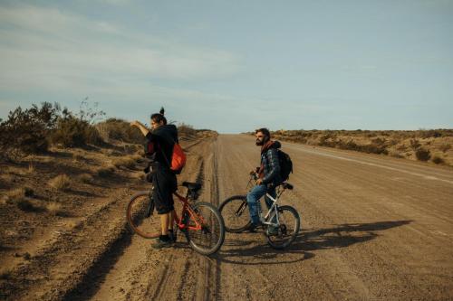 玛德琳港Chepatagonia Hostel & Experiences的两个人骑着自行车在土路上