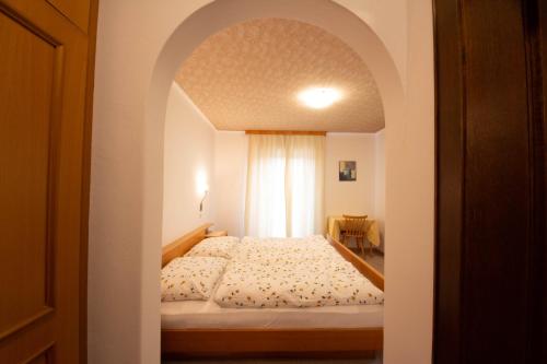 科拉尔博Ameiserhof Guesthouse的一间卧室配有一张带拱门的床