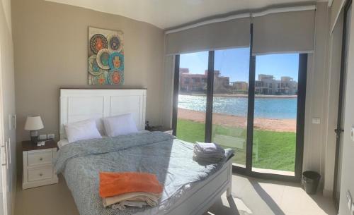 赫尔格达Tawila, 4 Bedroom Villa, Brand new, directly on a lagoon的一间卧室设有一张床和一个大窗户