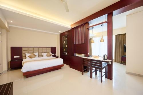 VandiperiyārThekkady Gavi Suites的一间卧室配有一张床、一张桌子和一张书桌。