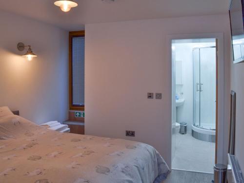 格洛索普Chunal Apartment - Uk12958的一间卧室配有一张床,浴室设有淋浴。