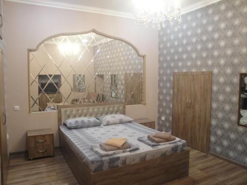 巴库apartament oriental tale in old cyti Baku的一间卧室配有一张带大镜子的床