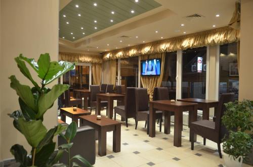 雅戈丁那Garni Hotel Lion的餐厅设有木桌、椅子和电视。