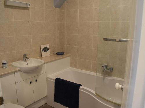 滨海索尔特本Skylight的一间带水槽、浴缸和卫生间的浴室