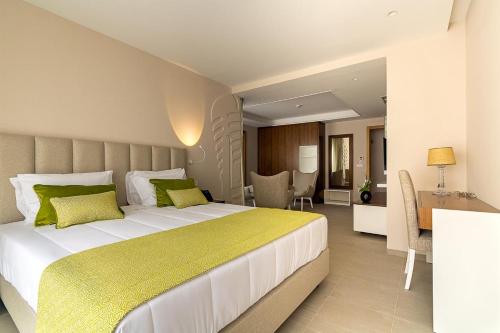 明德卢Luna Boutique Hotel的一间卧室配有一张带绿色枕头的大床