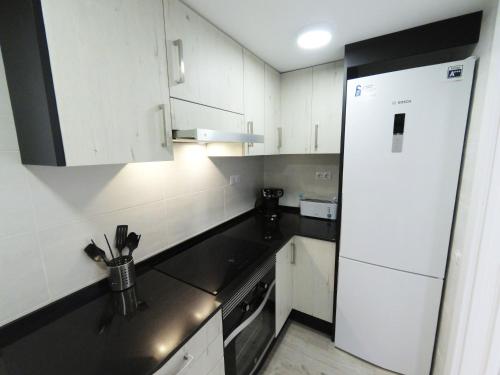 塔拉戈纳Apartamento New Tarraco的厨房配有白色橱柜和白色冰箱。