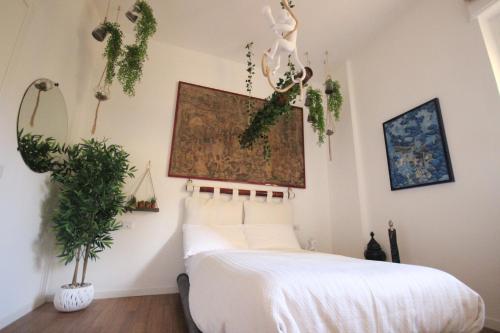 卡利亚里Il Chiostro的卧室配有床,墙上挂着植物