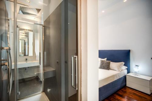 罗马Pgrhome Luxury Apartments Riverside的一间带玻璃淋浴的浴室和一张床