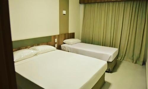 卡达斯诺瓦斯Prive Praias do Lago Eco Resort的两张位于酒店客房的床,配有两张sidx sidx单人床
