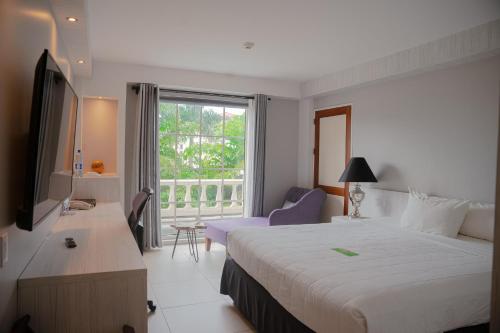 帕拉马里博皇家托拉里卡酒店的一间设有大床和窗户的酒店客房