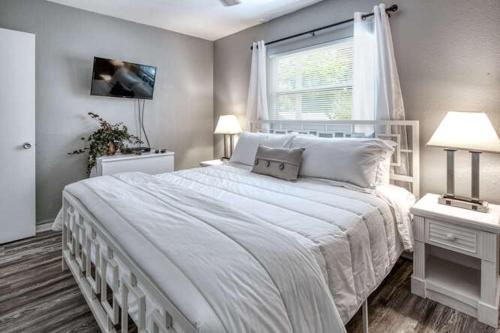 圣徒皮特海滩Sunset Beach Suites的卧室设有一张白色大床和一扇窗户。