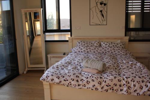 米德希特本-古里安נס הבריאה的一间卧室配有一张床和被子