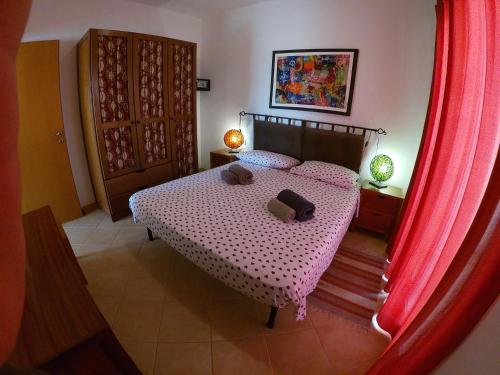 圣玛丽亚Casa Bahia 4的一间卧室配有一张带红色窗帘的床