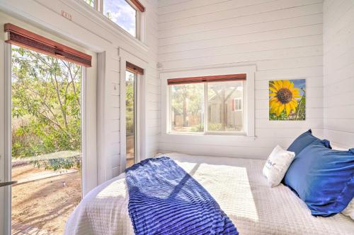 ClarkdaleModern Clarkdale Tiny Home on Mingus Mountain的一间卧室配有一张带蓝色枕头的床和一扇窗户。