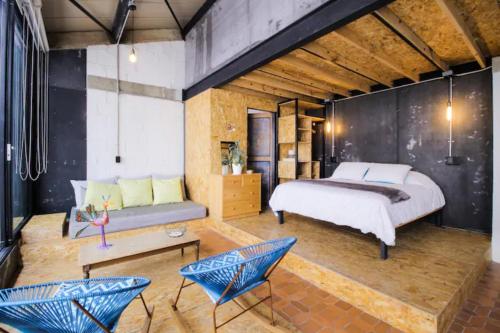 卡利Santa Teresita Loft的一间卧室配有一张床、一张沙发和椅子