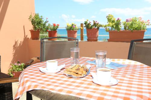 普洛马里翁阿库拉奥吉利酒店的一张桌子,上面有一张带 ⁇ 合桌布的桌子,上面有食物