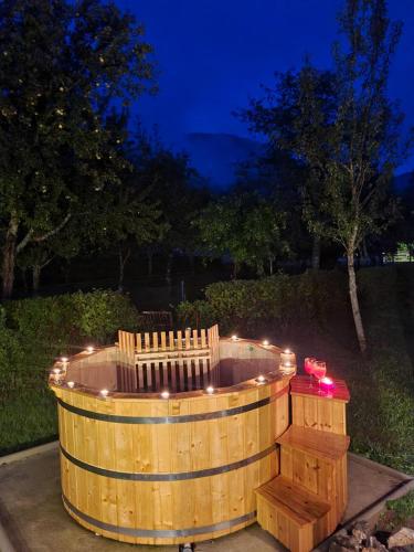 Brod na KupiCasa Valle的夜间在院子里设有灯光的木制热水浴缸