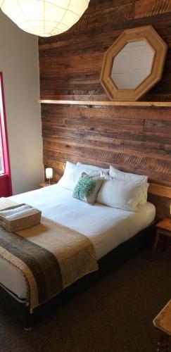 纳塔列斯港Treehouse Patagonia的一间卧室设有一张带木墙的大床